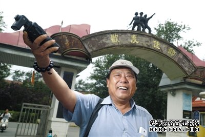 北京电影厂外，赵士轩用闪光灯打亮自己。平时，他都坐在这里等待演戏机会。赵士轩曾是一名法官，退休后为圆演戏梦，成为北影厂门口的一名群演。