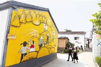 6月20日，游客在馆陶县粮画小镇寿东村参观。寿东村植入粮画这个特色产业，产业、文化、旅游同步推进，入选2015年中国十大最美乡村。记者 赵永辉摄