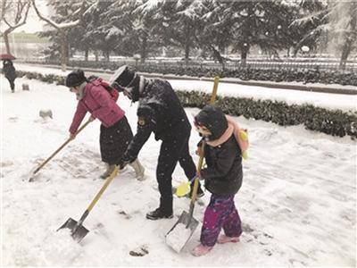 韩军一家三口在扫雪。 魏剑 摄