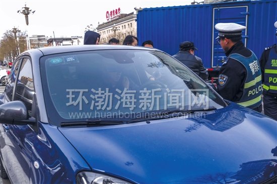 图为交警对一位在驾驶途中接打电话的司机进行处罚。记者 赵亮 摄
