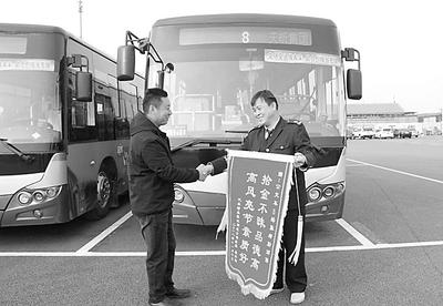 乘客屈先生给沧州公交车长张绪勤（右一）送来锦旗